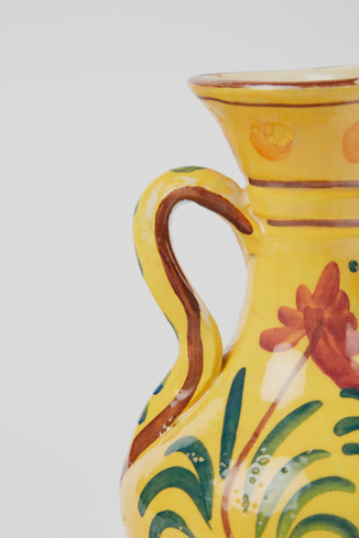 Close-up view of Yellow jug Yellow antique ceramic jug with floral motif