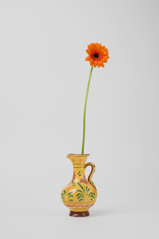 Front view of Yellow jug Yellow antique ceramic jug with floral motif