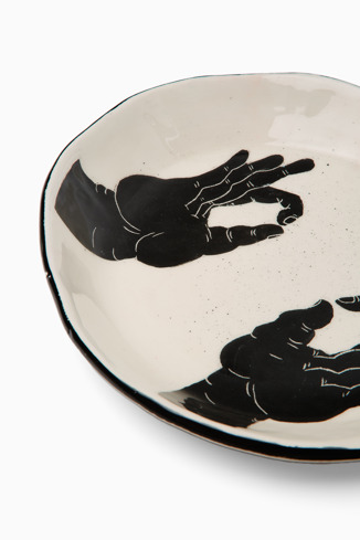 Close-up view of Ceramic plate with hands White and black handmade plate